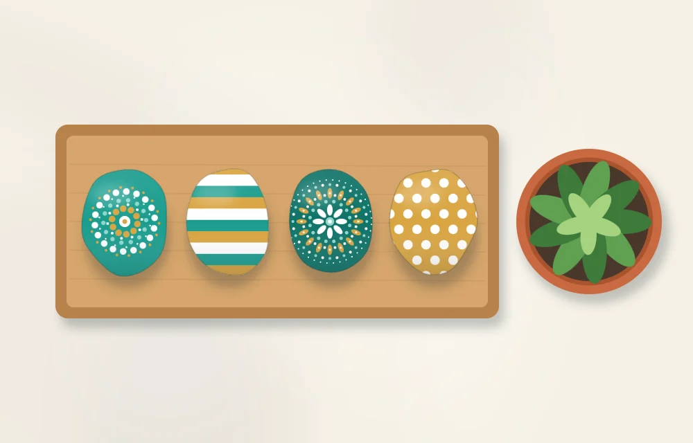 A wooden tray holding a row of painted stones in a coordinated palette next to a small potted plant
