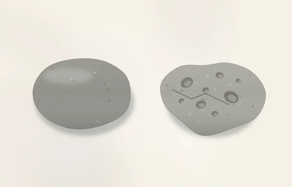 Two bare stones side by side: a smooth, flat oval stone on the left and a rough, pitted, jagged stone on the right