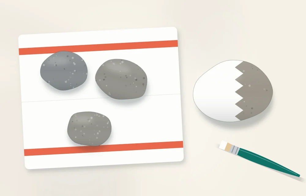 Clean stones drying on a towel, with one stone half covered in a white base coat and a flat brush beside it