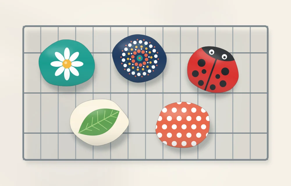 Five painted stones resting on a wire cooling rack so that air can reach all sides