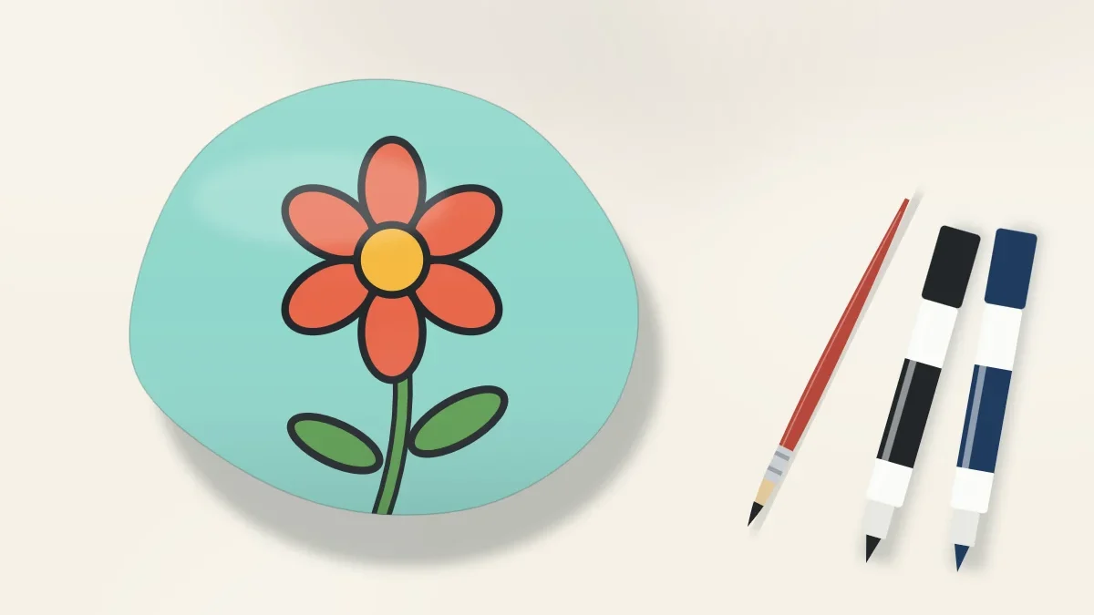 A stone with a flower design sharply outlined in black, next to a thin liner brush and two fine paint pens