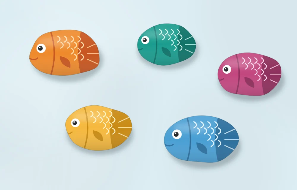 Five fish stones in different colors all facing the same way on a pale blue surface