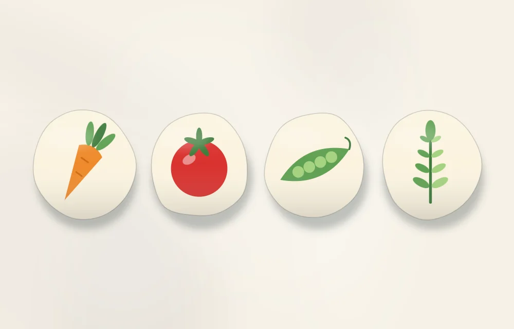 Four marker stones in a row, each with a simple picture: a carrot, a tomato, a pea pod and a sprig of herbs