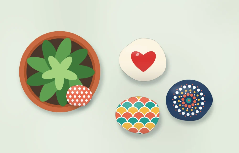 Gift set laid out: a small potted plant with a painted stone in the pot, a heart stone and two patterned stones