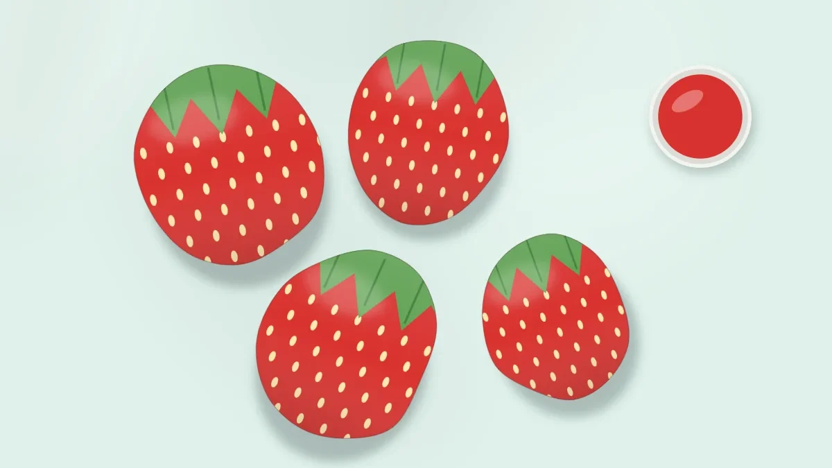 Four stones painted as red strawberries with green leafy tops and small pale seeds, grouped together with a small pot of red paint