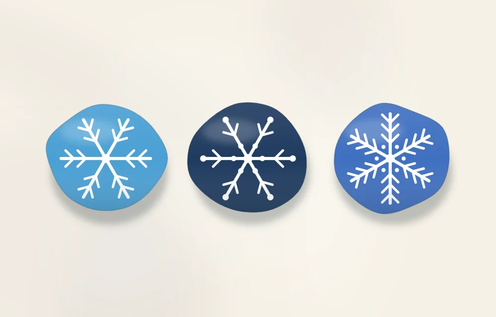 Three blue stones painted with different white snowflake designs